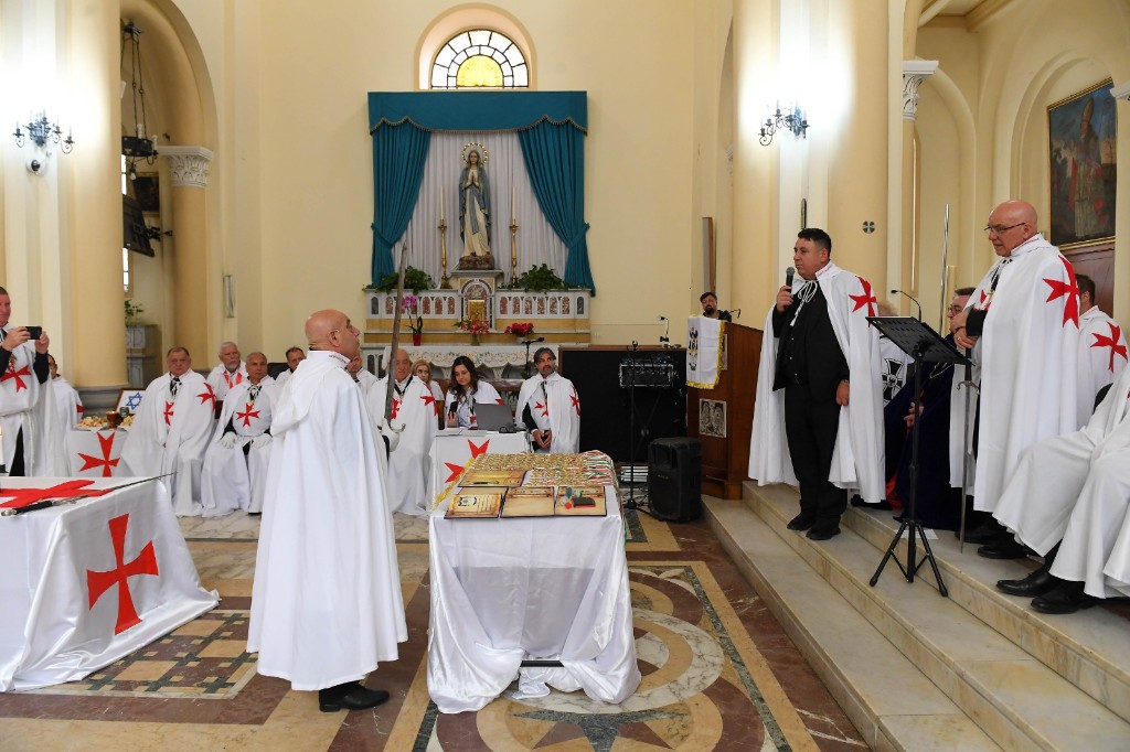 Cérémonie dans l’église, avec un orateur à l’ambon et la bannière Ordo Equestri Sancti Bernardus